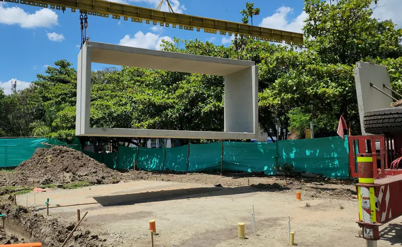 Grúa izando un marco prefabricado de concreto sobre el lote