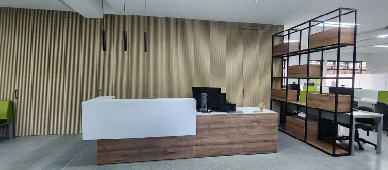 Recepción con mueble blanco y madera frente a un muro en listones