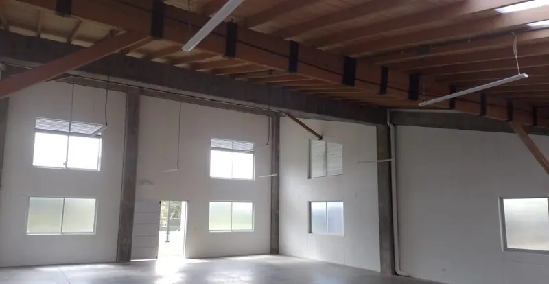 Salón de doble altura con cubierta en madera y ventanas altas